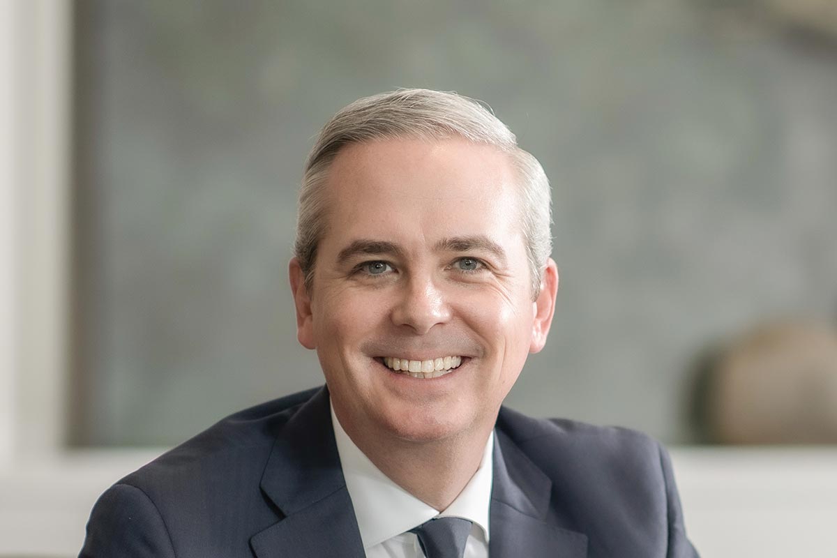 Evan Beattie, Principal and CEO at GFF, close-up portrait in navy suit and tie with soft natural light.