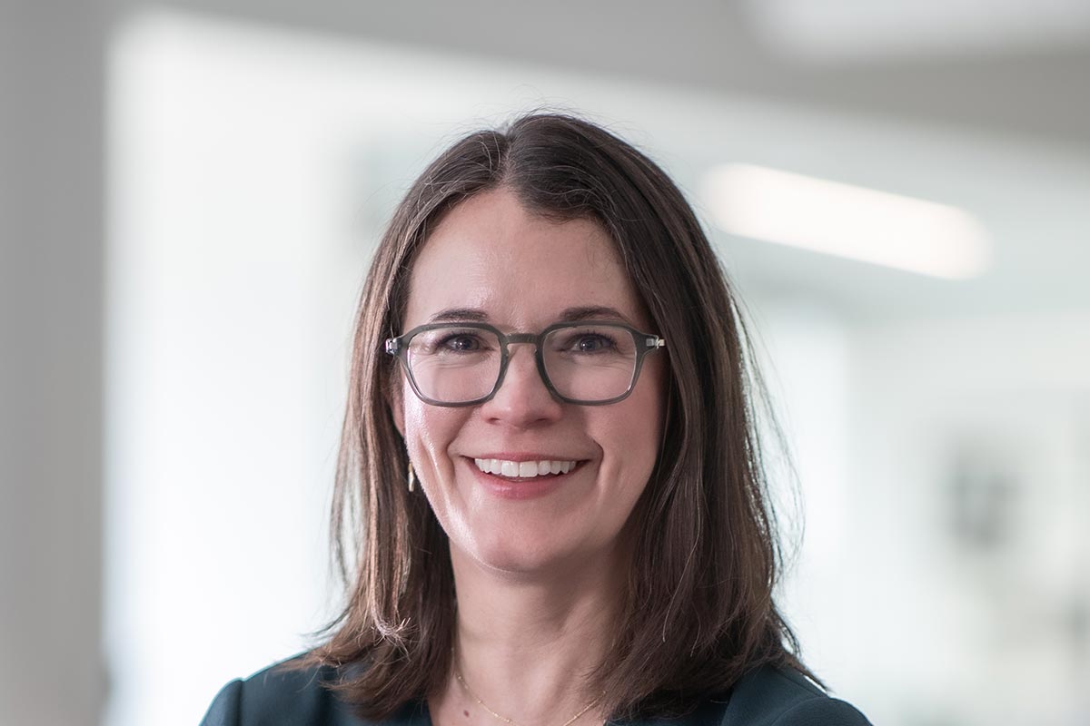Jacquelyn Block, AIA, LEED AP, Principal and Director of Faith & Community Practice at GFF, close-up portrait with glasses in soft-focus office background.