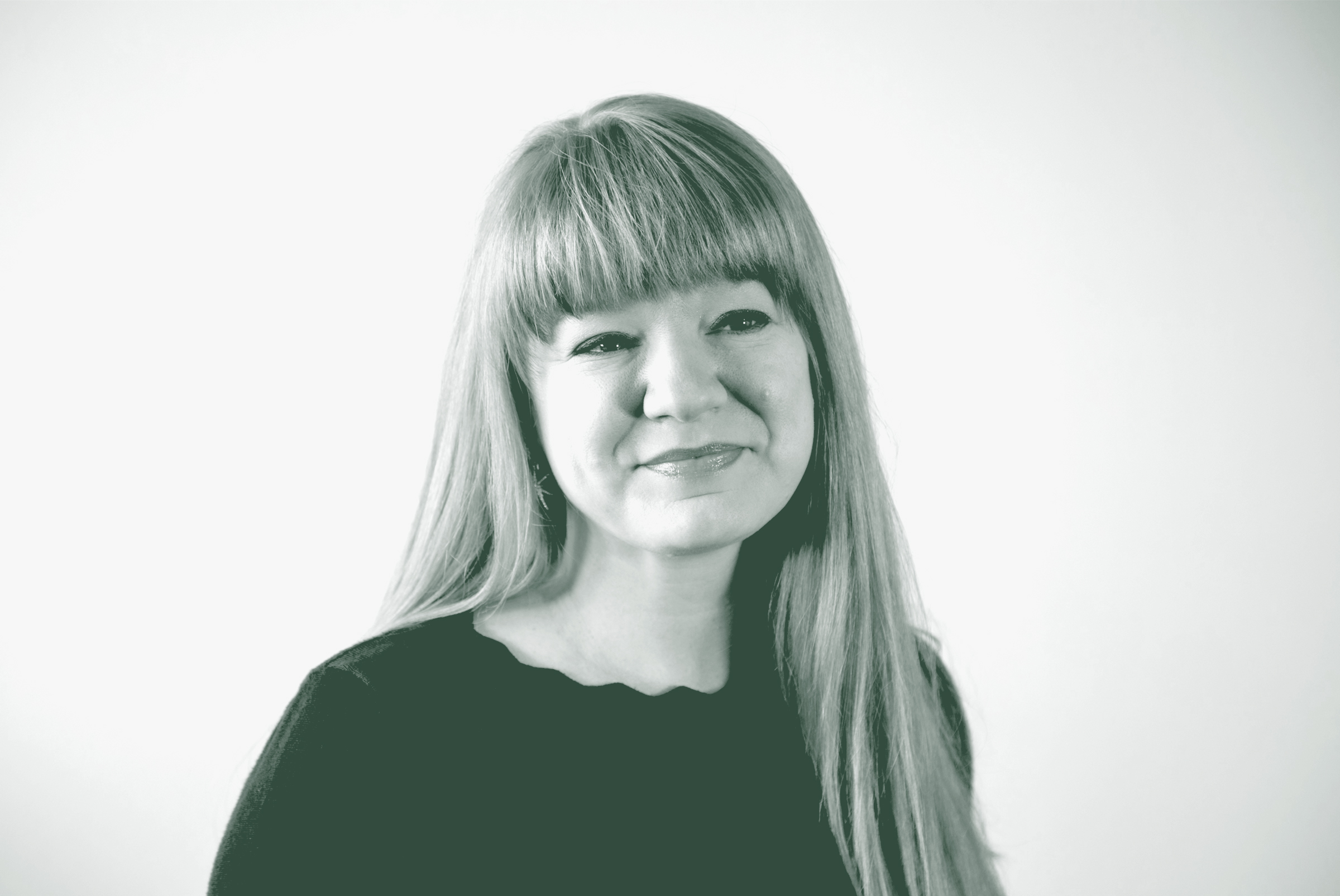 A black and white portrait of Emily Mendez, an Associate, the Director of Sustainability, and an Interior Design Leader with GFF in the Church Works Studio, in front of a white background.