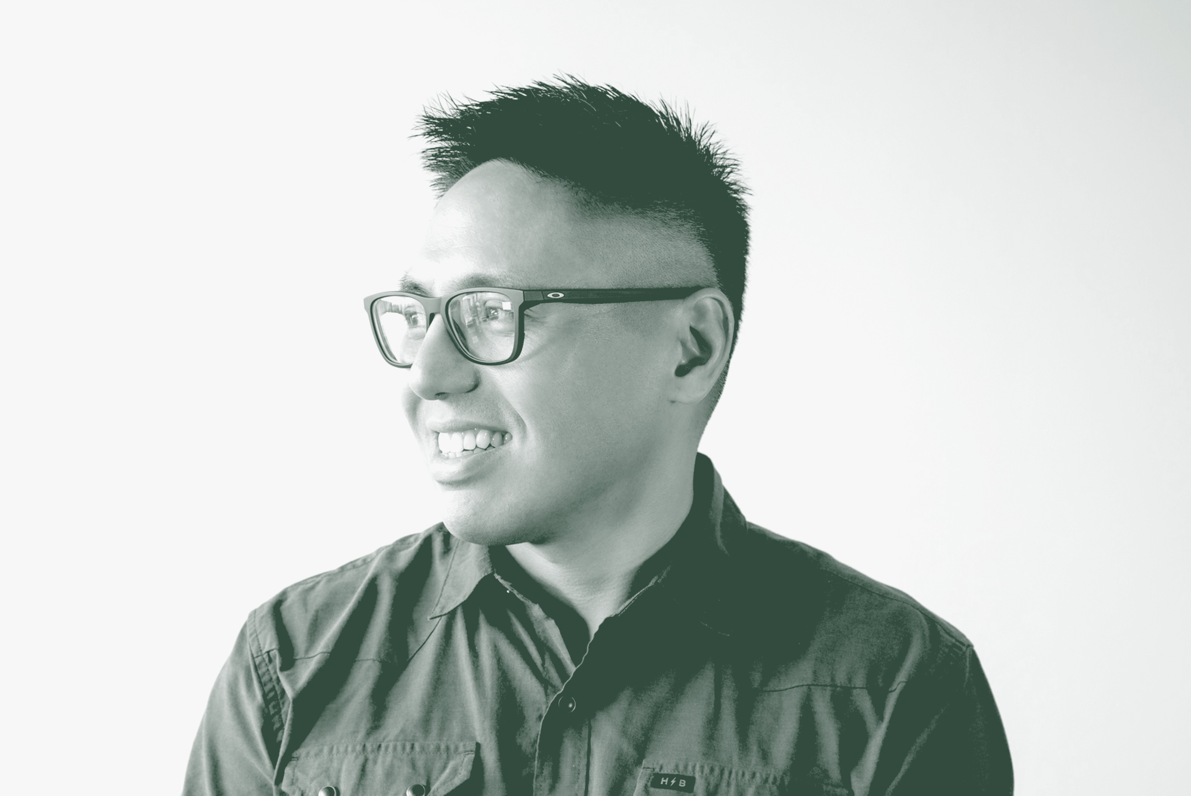 A black and white portrait of Lance Abaya, an Associate and Senior Design Leader with GFF in the Retail Studio, in front of a white background.