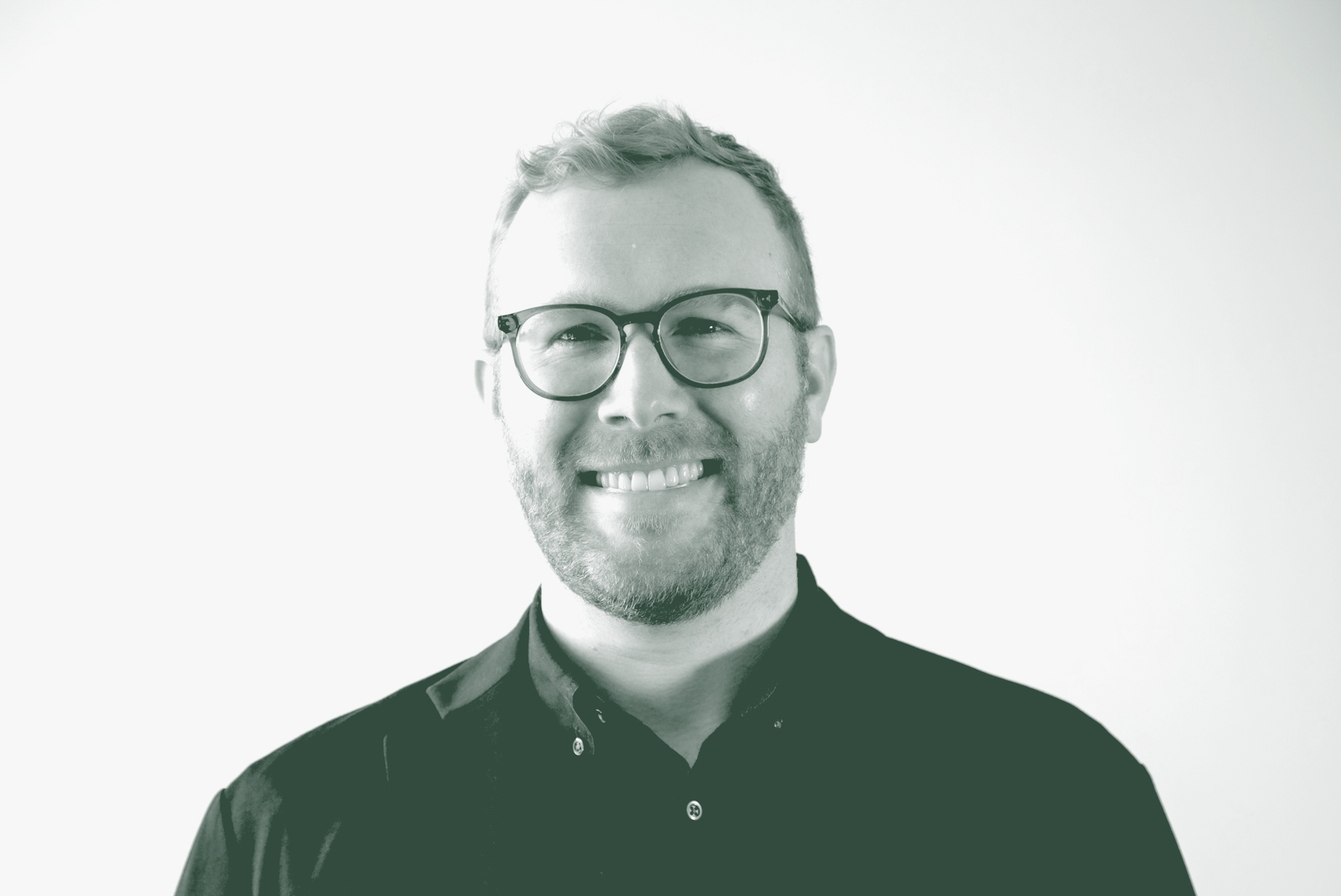 A black and white portrait of Blake Thames, an Associate and Design Leader with GFF, in front of a white background.