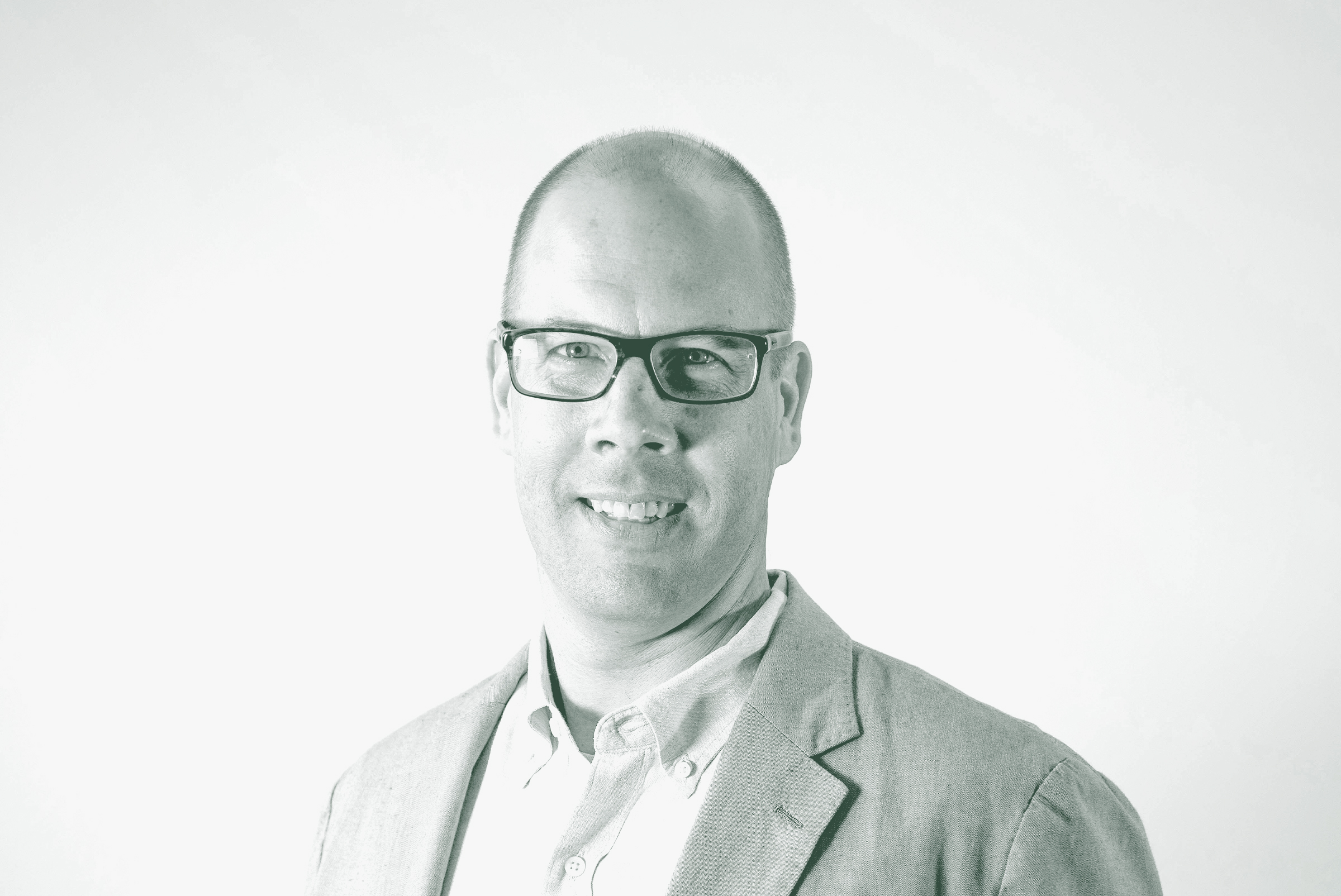 A black and white portrait of Aaron Hunt, an Associate Principal and the Managing Director – Fort Worth with GFF in the Fort Worth Studio, in front of a white background.