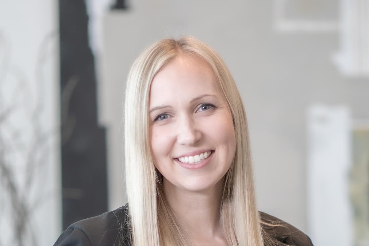 Alix Rios, Associate Principal and Studio Director at GFF, close-up headshot with straight blonde hair and a black blazer, photographed in a modern office environment.