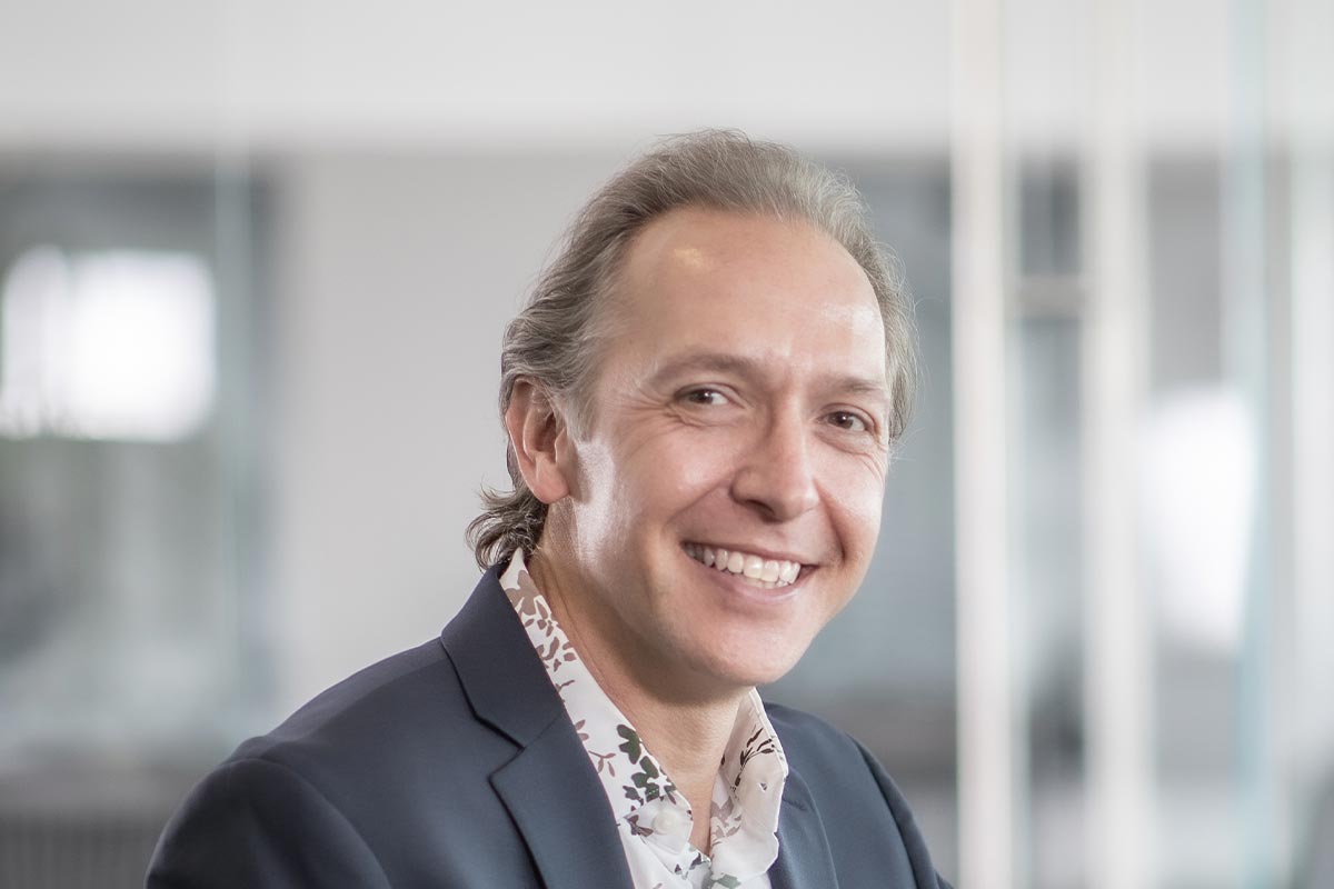 A cropped landscape portrait of Michael Lehr, Associate Principal and Studio Director at GFF, smiling in a bright modern office interior.