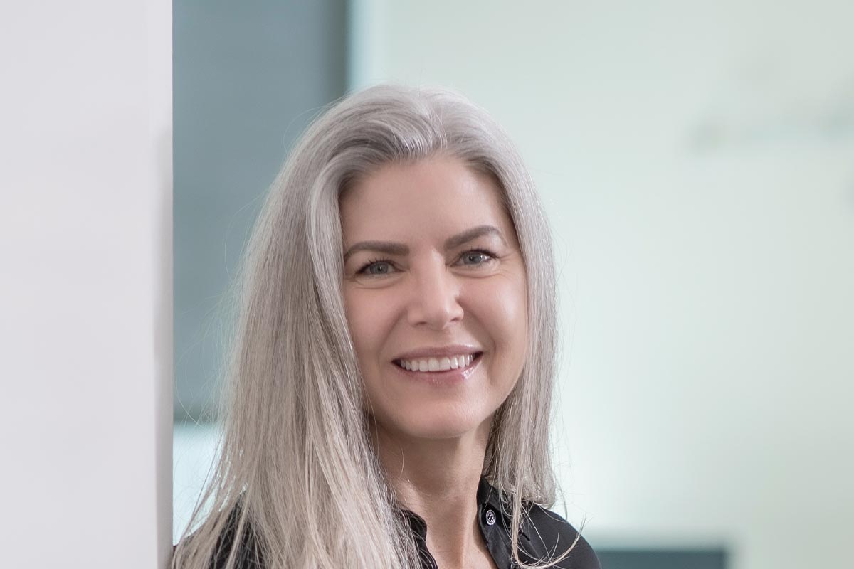 A cropped landscape portrait of Danielle Davis, Associate and Director of Accounting at GFF, smiling in a softly lit professional setting.