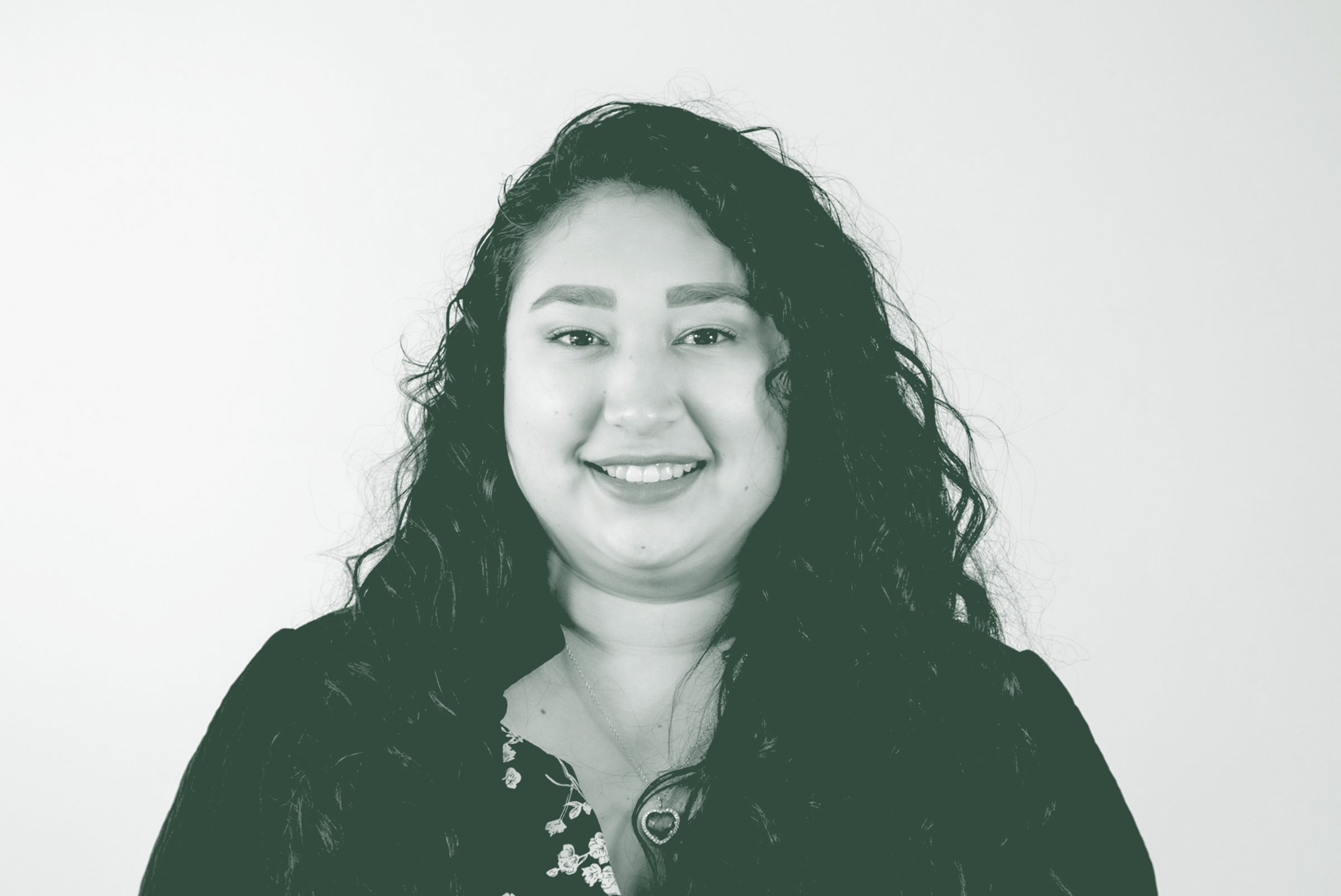 A black and white portrait of Tuesdie Alonso, a Senior Project Coordinator with GFF in the Fort Worth Studio, in front of a white background.