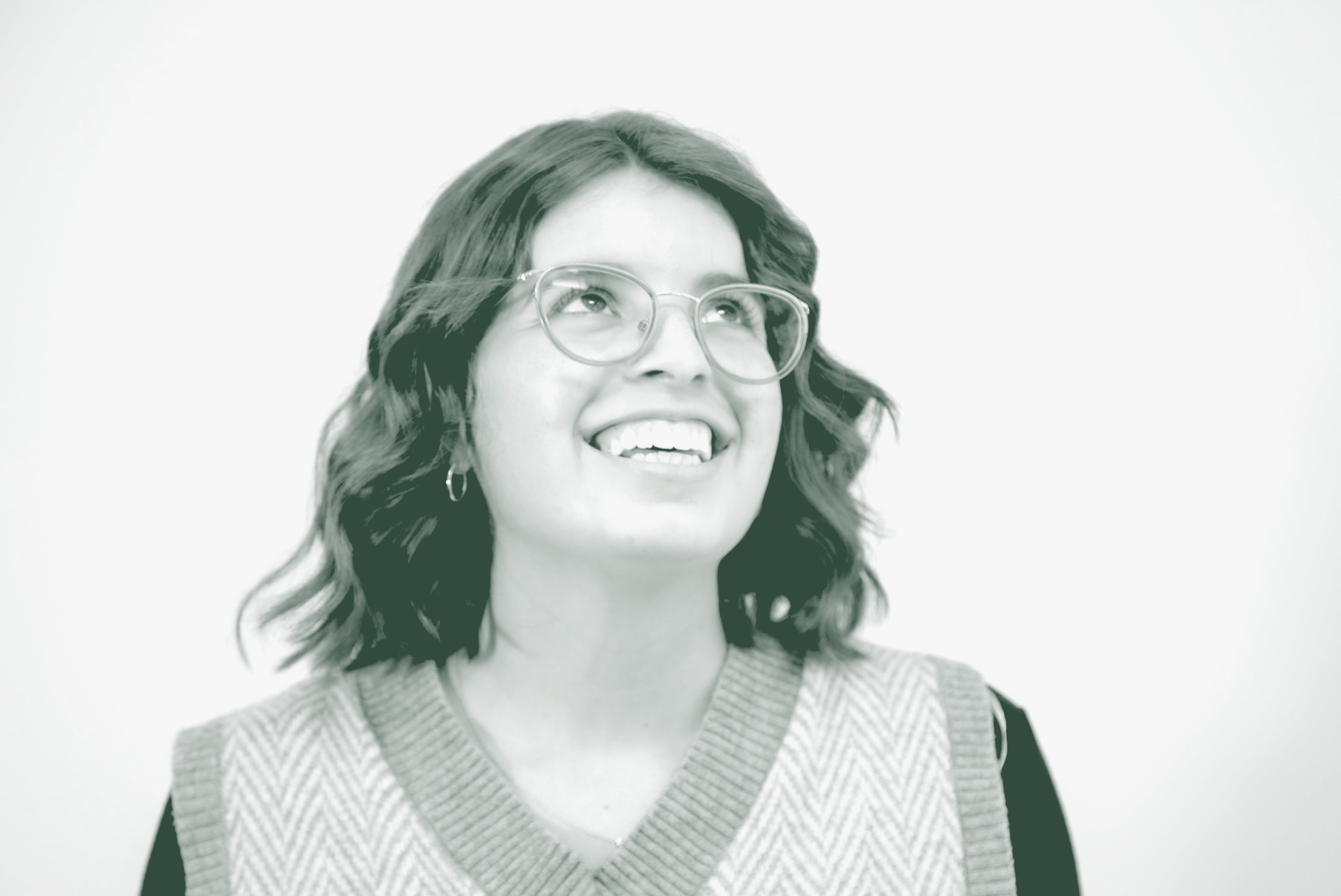 A black and white portrait of Gabrielle Duran, a Project Coordinator with GFF in the Austin Studio, in front of a white background.