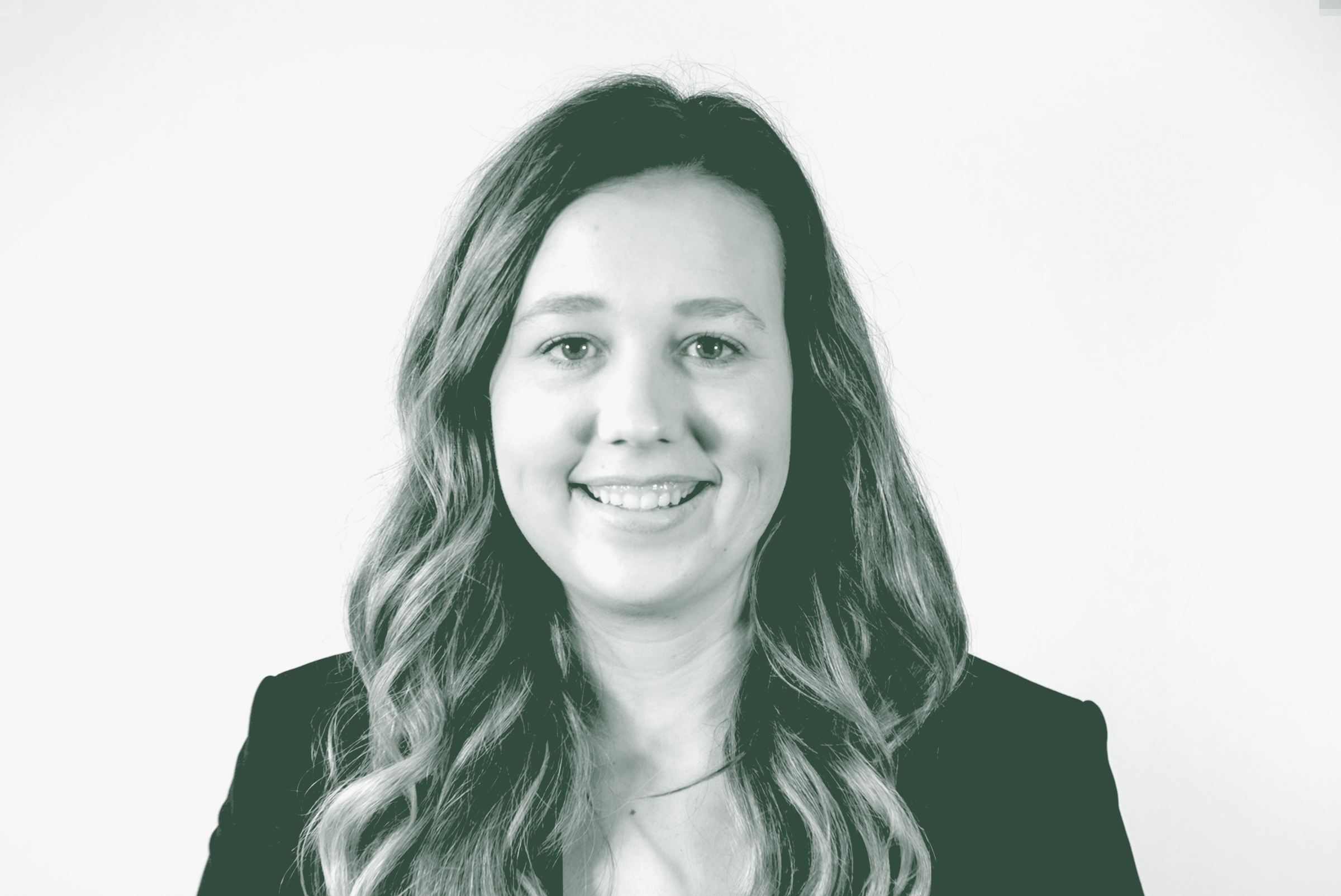 A black and white portrait of Kelsey Kohlmeier, a Project Coordinator with GFF in the Education Studio, in front of a white background.