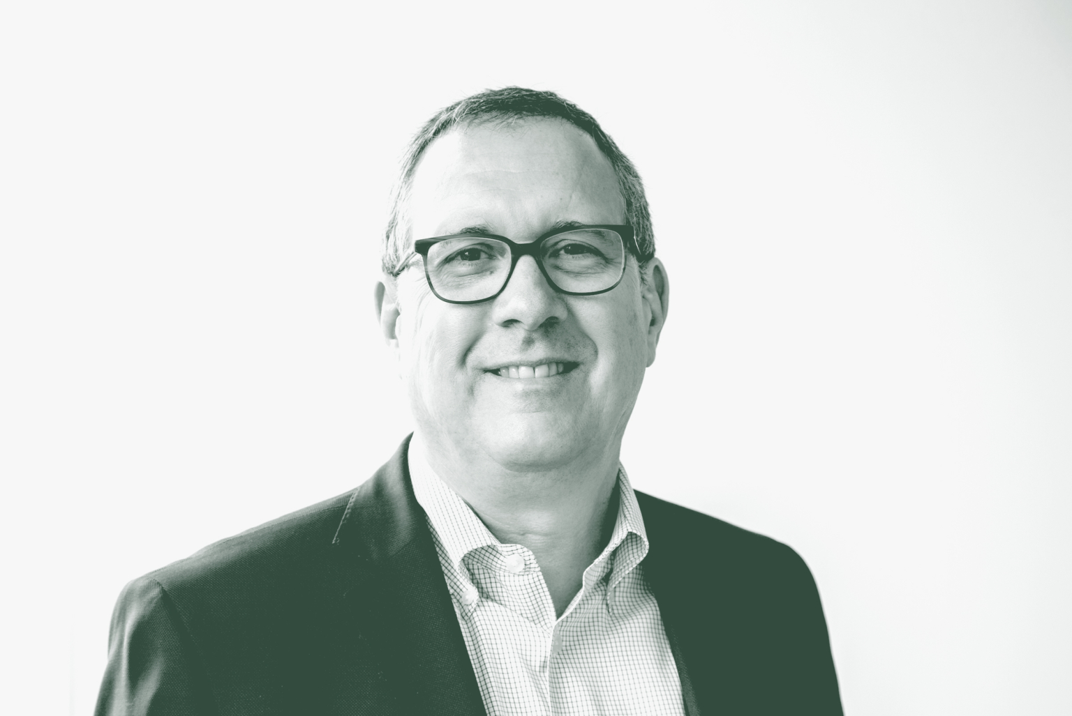 A black and white portrait of Steve Brookover, an Associate and Senior Project Leader with GFF in the K-12 & Higher Ed Studio, in front of a white background.