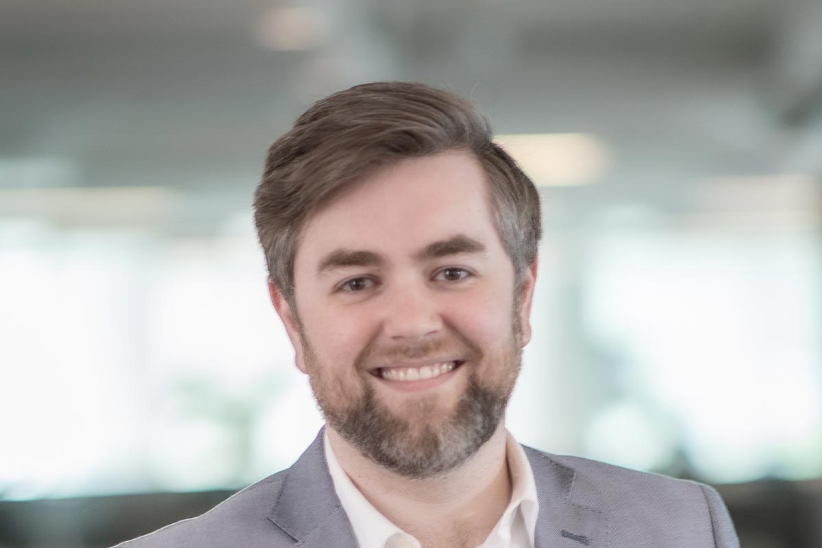 A cropped landscape portrait of Josh Frederick, Associate and Project Leader at GFF, smiling in front of a softly lit office background.