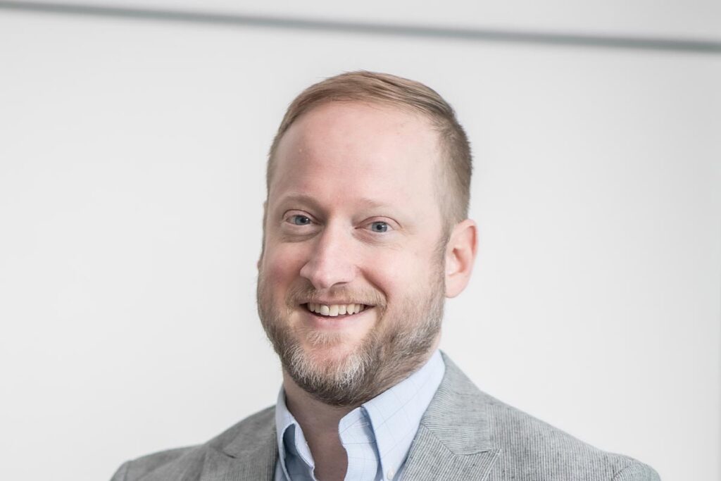 A cropped landscape portrait of David Anderson, Senior Project Leader at GFF, smiling in a bright neutral-toned setting.
