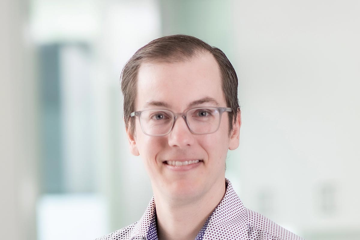A cropped landscape portrait of Matt Frame, Project Leader at GFF, smiling in front of a softly lit office background.