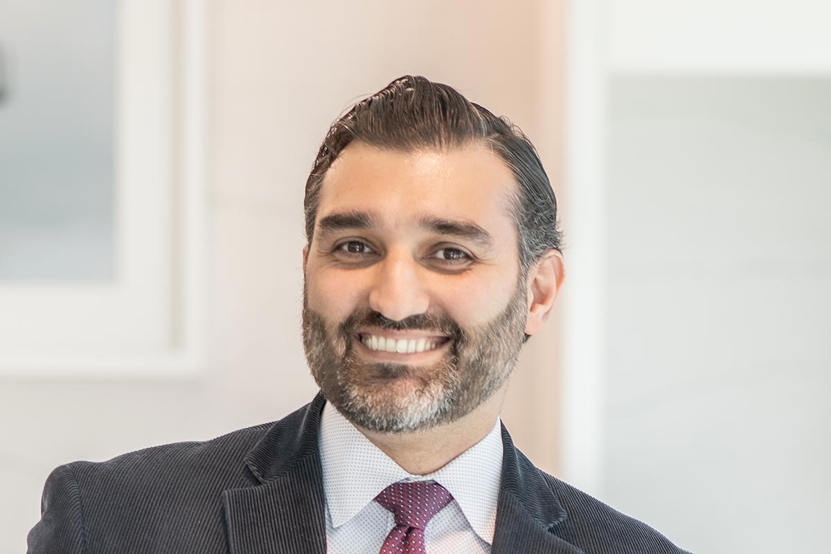 A cropped landscape portrait of Shayan Baradaran, Project Leader at GFF, smiling in front of a softly blurred office background.
