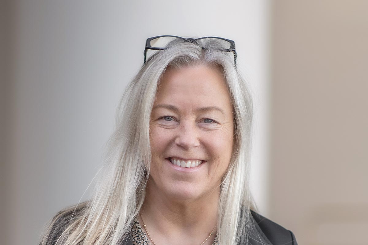 A cropped landscape portrait of Lena Starostine, Senior Project Coordinator at GFF, smiling in a softly lit modern interior.