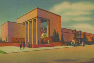 Perspective rendering from a historic color postcard showing the Food & Fiber Building in its original state. Visitors walk toward the tall entry colonnade of the beige, Art Deco hall.