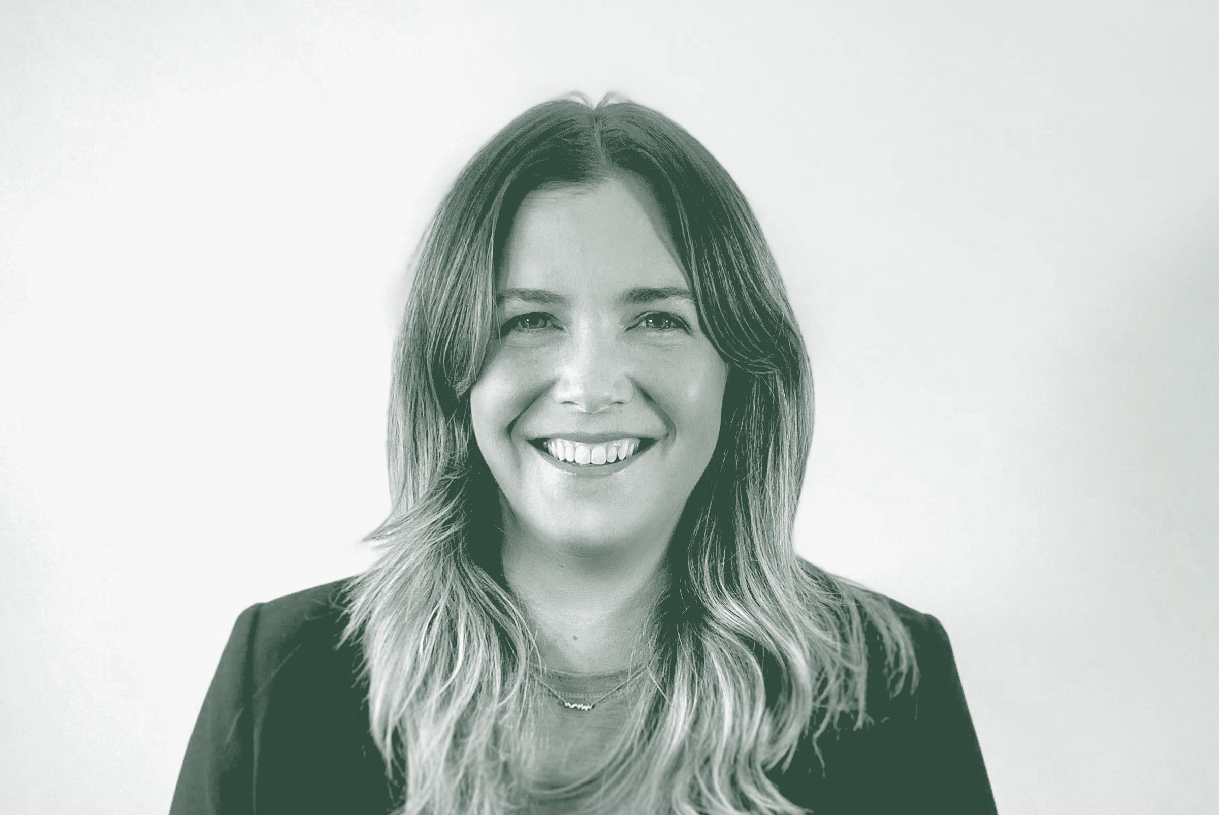 A black and white portrait of Jenna Ross, an Interior Design Leader with GFF in the Austin Office, in front of a white background.