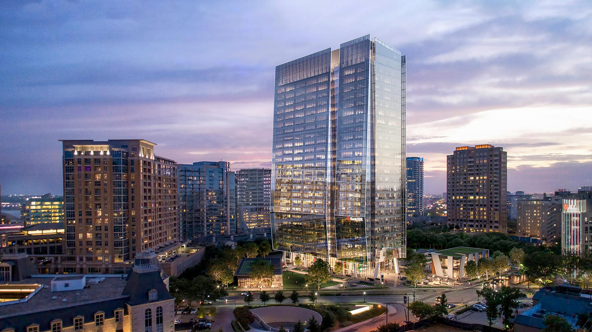 Aerial View Skyline view of 23Springs in Uptown Dallas at dusk, showing the glass tower above its landscaped plaza and two street-facing restaurant buildings.