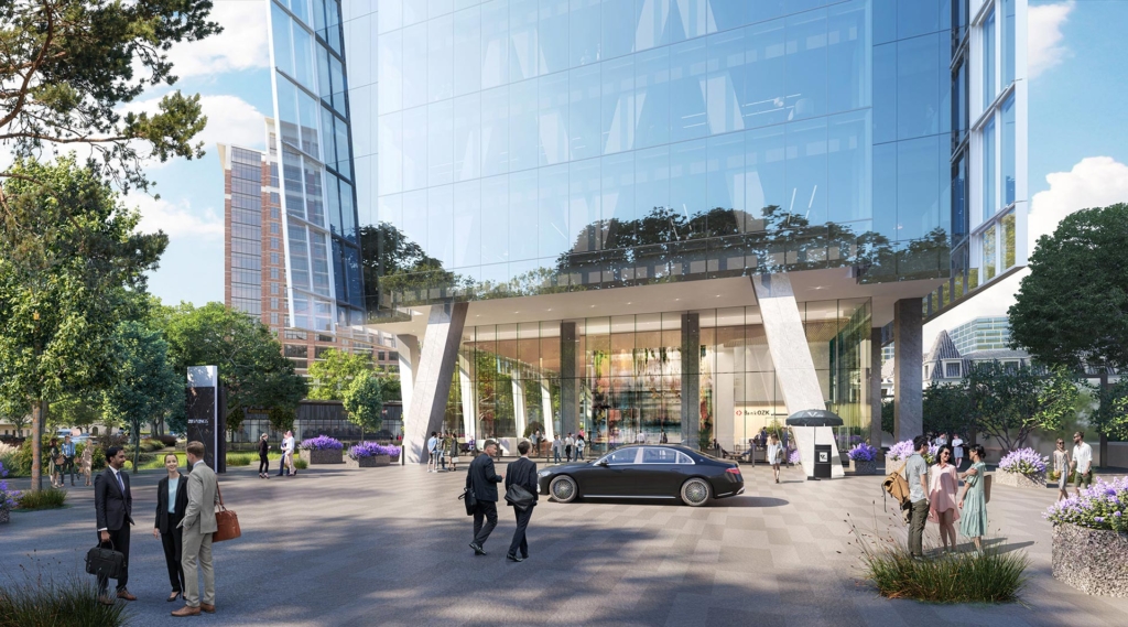 Motor Court Street-level view of 23Springs motor court with glass façade, valet station, art-filled lobby, and people arriving at the building entrance.