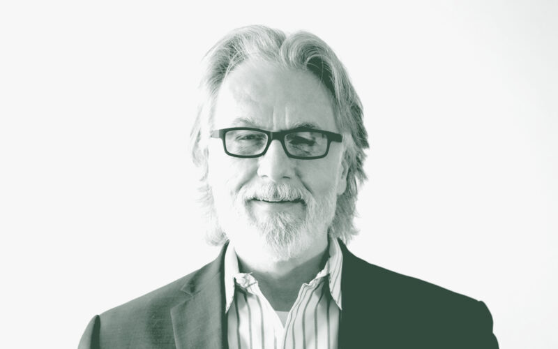 A black and white portrait of Brian Kuper, the Design Principal with GFF, in front of a white background.