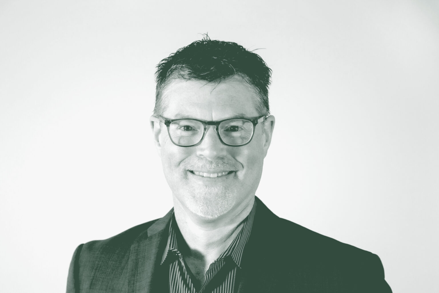 A black and white portrait of Brian Moore, a Principal and the Director of Planning with GFF in the Planning Studio, in front of a white background.