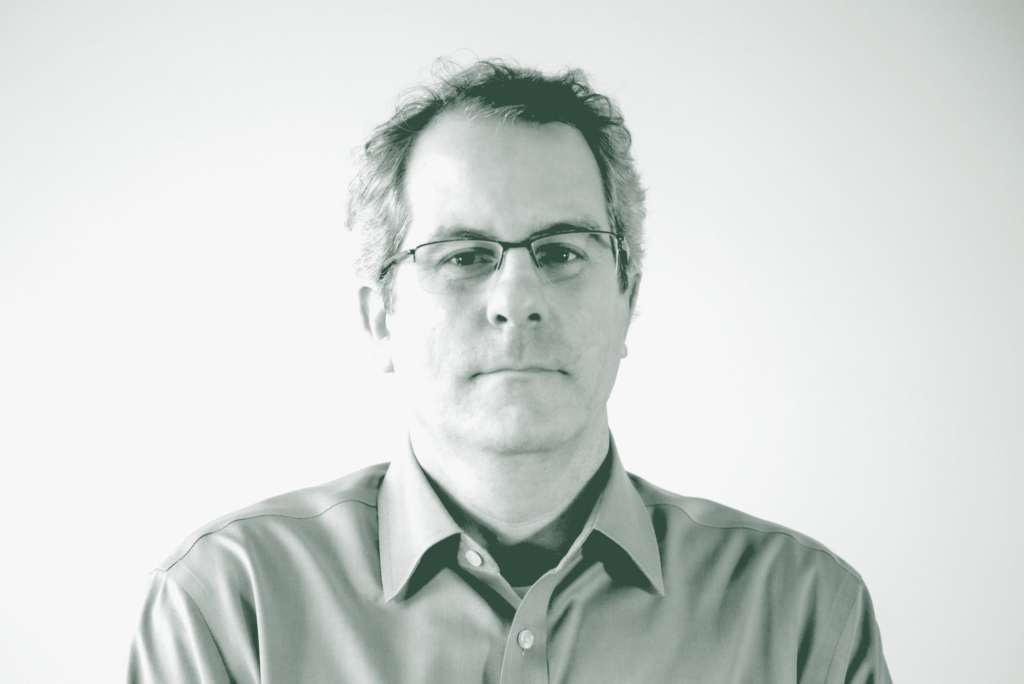 A black and white portrait of David Boone, an Associate Principal and Senior Project Leader with GFF in the Interior Design Studio, in front of a white background.