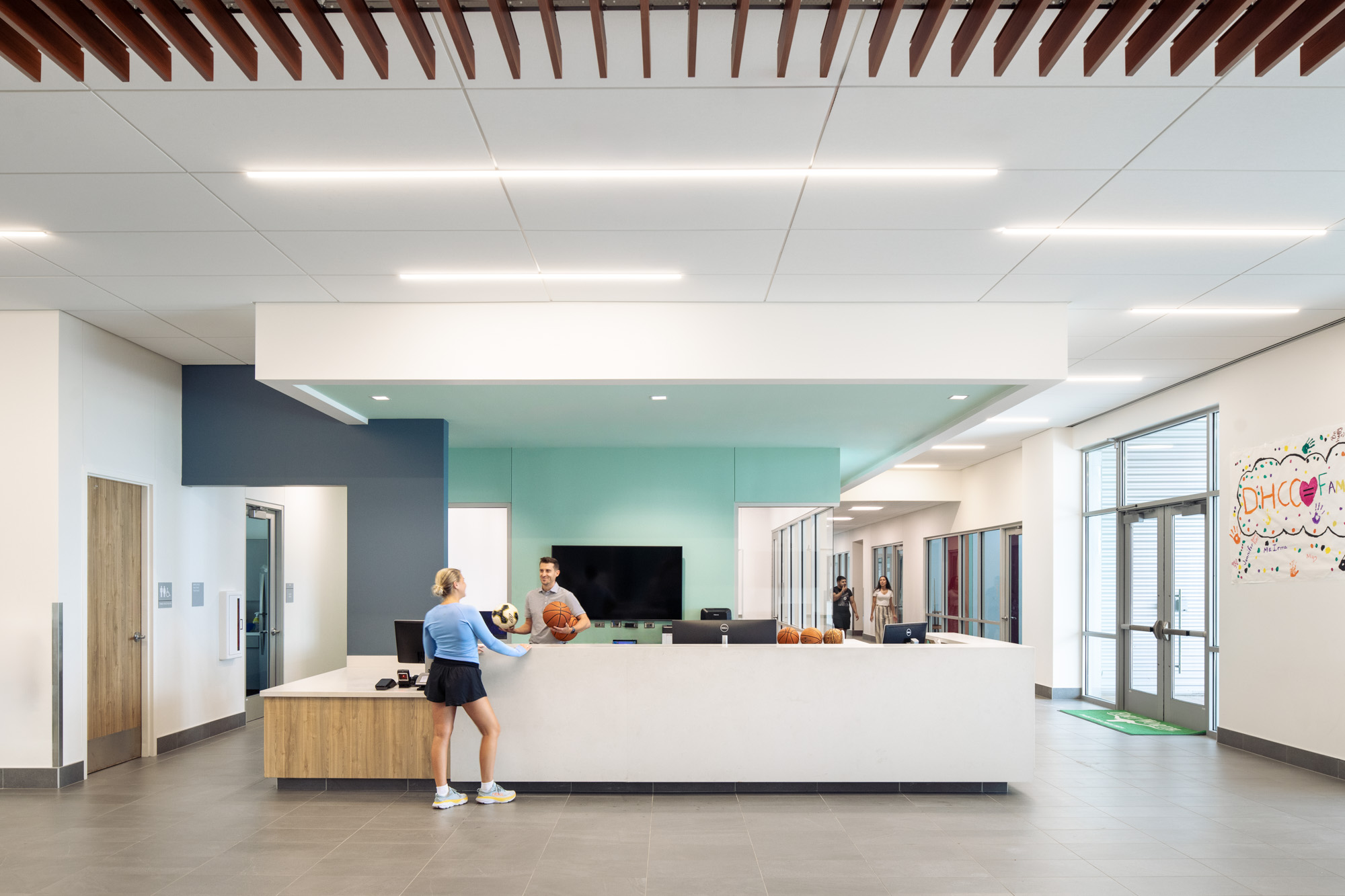 The reception area of the Diamond Hill Community Center with staff assisting a visitor in a bright, modern setting.