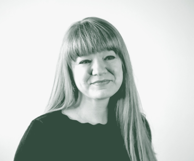 A black and white portrait of Emily Mendez, an Associate, the Director of Sustainability, and an Interior Design Leader with GFF in the Faith & Community Studio, in front of a white background.