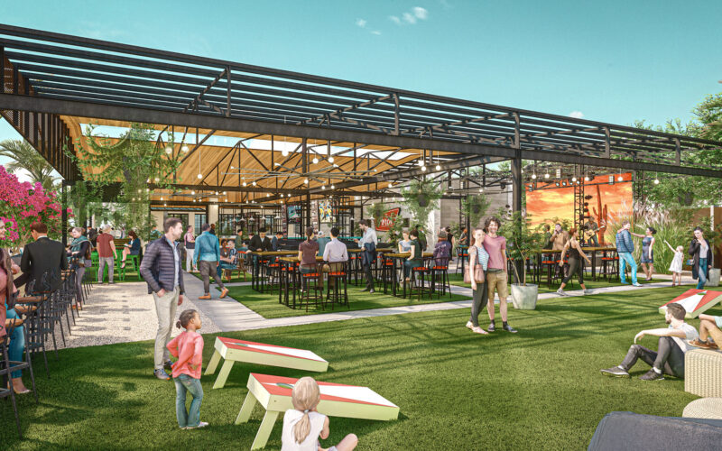 People enjoying indoor-outdoor restaurant space with seating and activities.