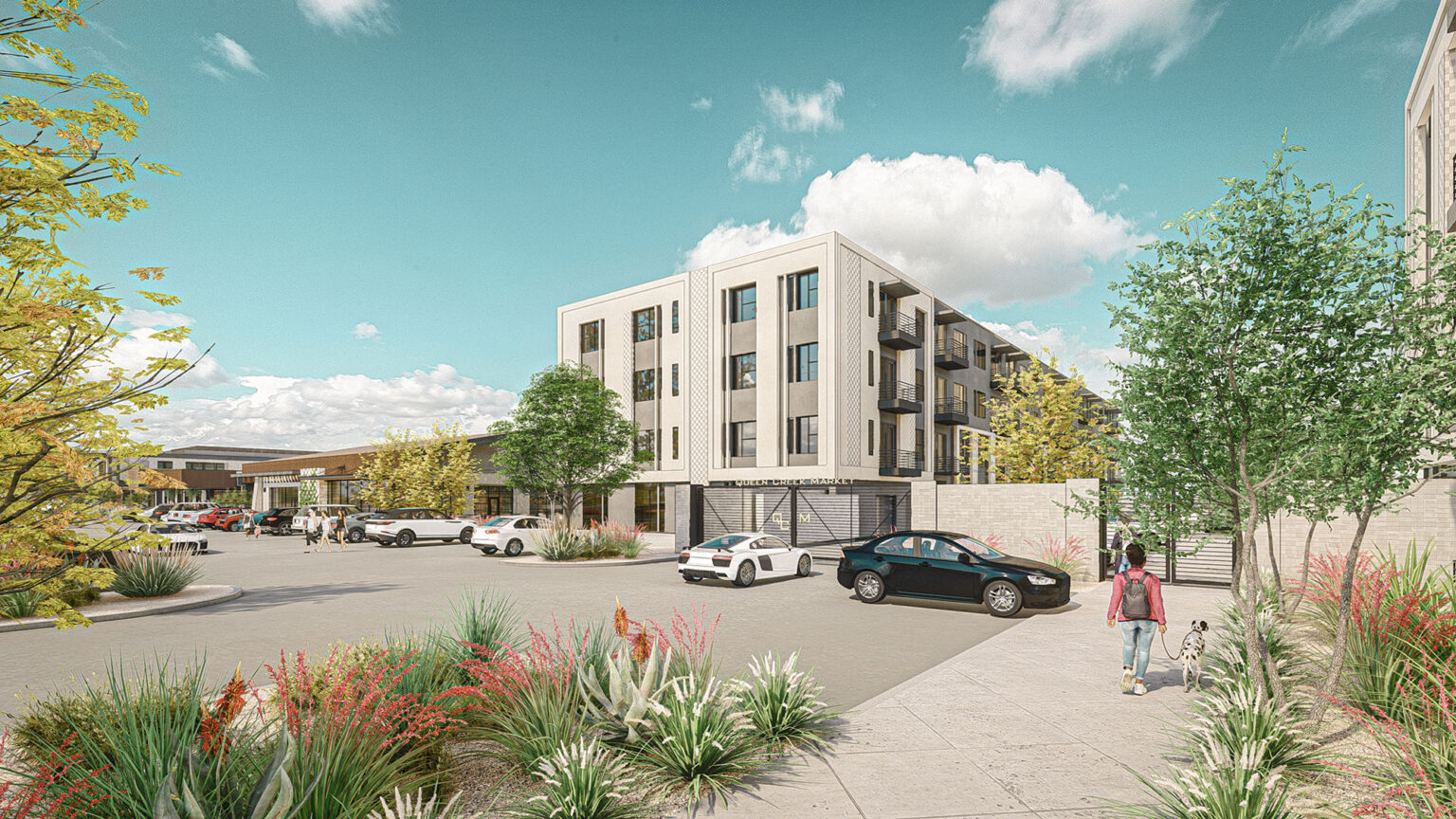 Four-story multifamily residential building with landscaped surroundings and parked cars.