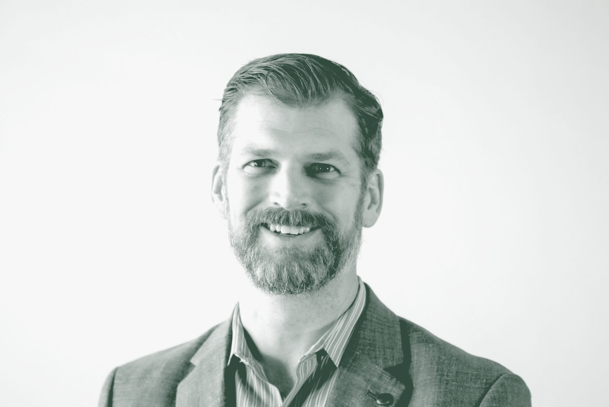 A black and white portrait of Grant Wickard, an Associate Principal and Senior Project Leader with GFF in the Retail & Hospitality Studio, in front of a white background.