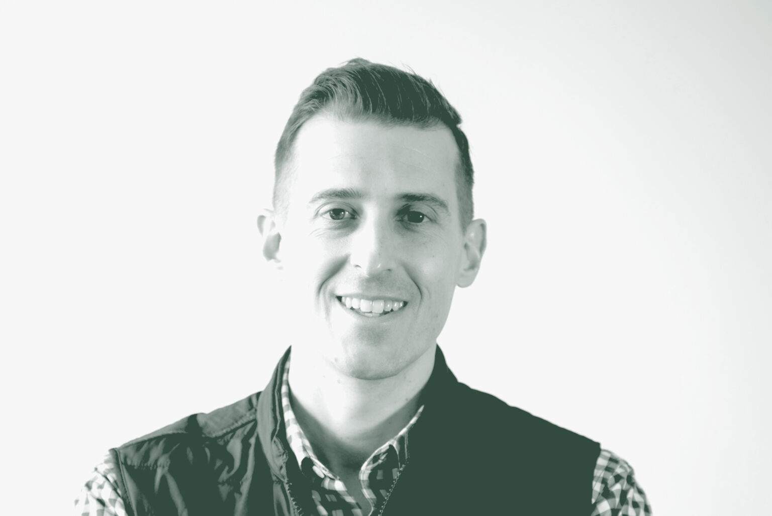 A black and white portrait of Jason Cave, an Associate Principal and the Director of Civic Practice with GFF in the Civic & Cultural Studio, in front of a white background.