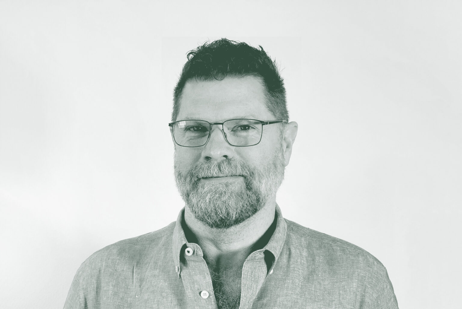 A black and white portrait of Jim West, a Principal and the Managing Director – Austin with GFF in the Austin Studio, in front of a white background.