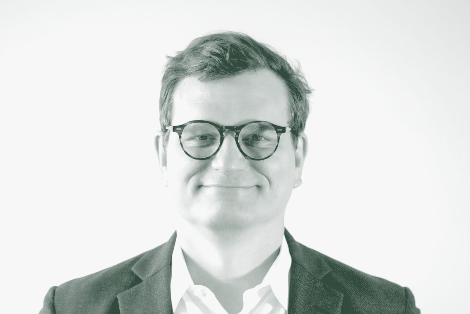 A black and white portrait of John Jacobson, a Senior Design Leader with GFF, in front of a white background.