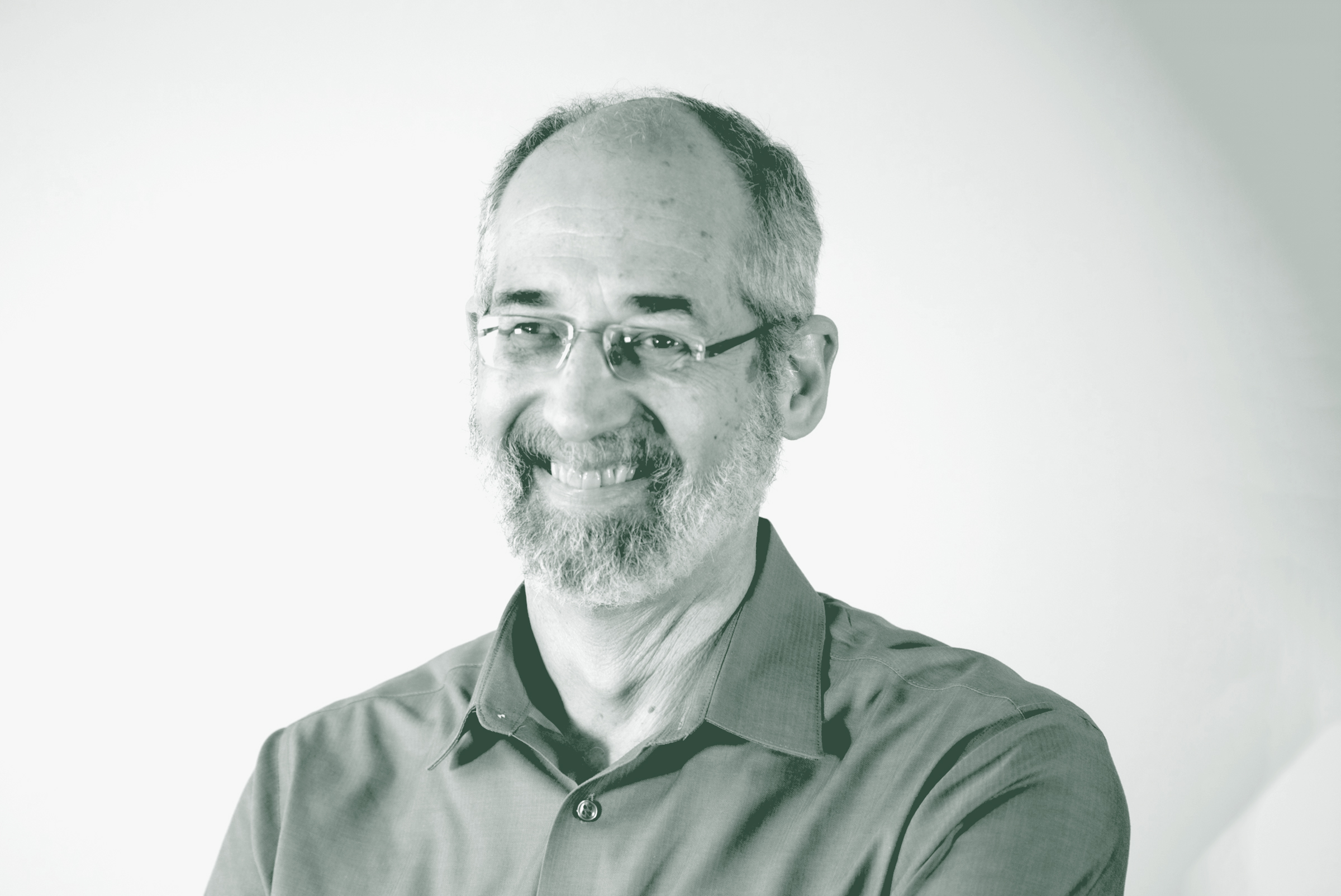 A black and white portrait of Jon Rollins, a Principal with GFF in the K-12 & Higher Ed Studio, in front of a white background.