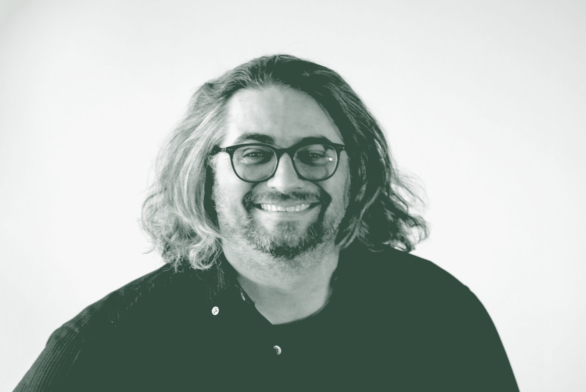 A black and white portrait of Loren Boynton, a Senior Design Leader with GFF in the Faith & Community Studio, in front of a white background.