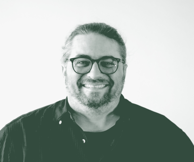 A black and white portrait of Loren Boynton, a Senior Design Leader with GFF in the Faith & Community Studio, in front of a white background.