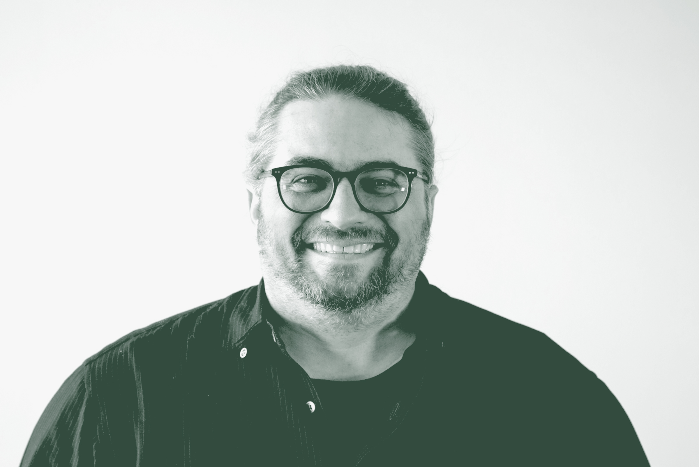 A black and white portrait of Loren Boynton, a Senior Design Leader with GFF in the Faith & Community Studio, in front of a white background.