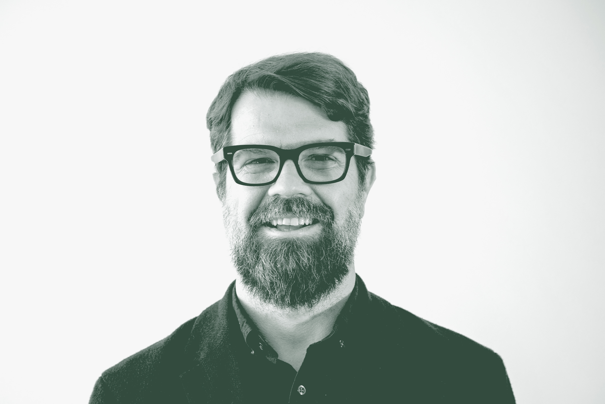 A black and white portrait of Mark Holsinger, an Associate Principal and Senior Design Leader with GFF, in front of a white background.