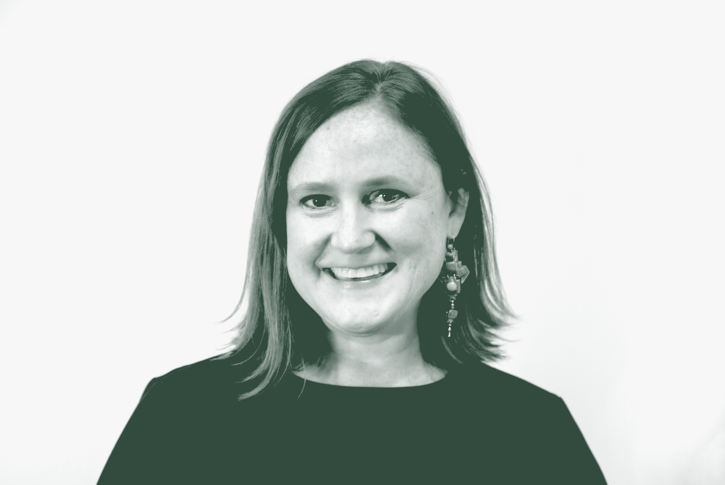 A black and white portrait of Sara Good, an Associate, Studio Director and Project Leader with GFF in the Austin Studio, in front of a white background.