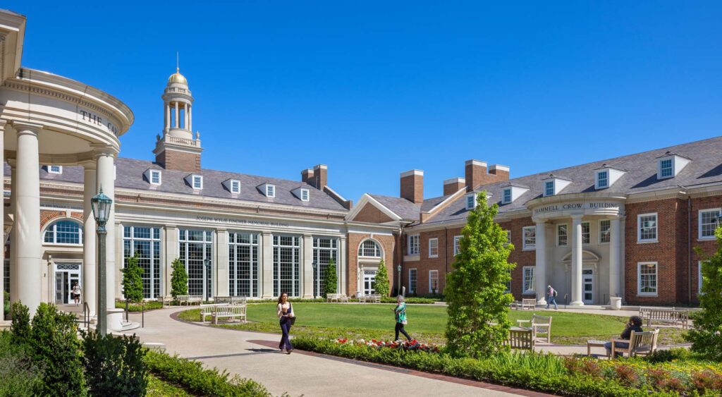 Courtyard lawn at the SMU Cox School of Business framed by historic brick academic buildings and columned facades with clear campus sightlines.
