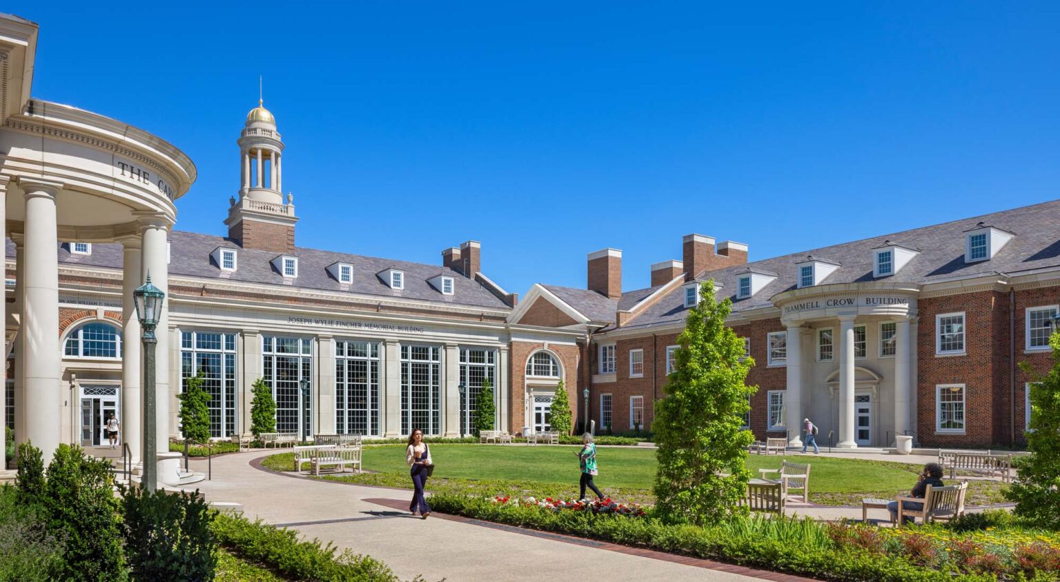Courtyard lawn at the SMU Cox School of Business framed by historic brick academic buildings and columned facades with clear campus sightlines.