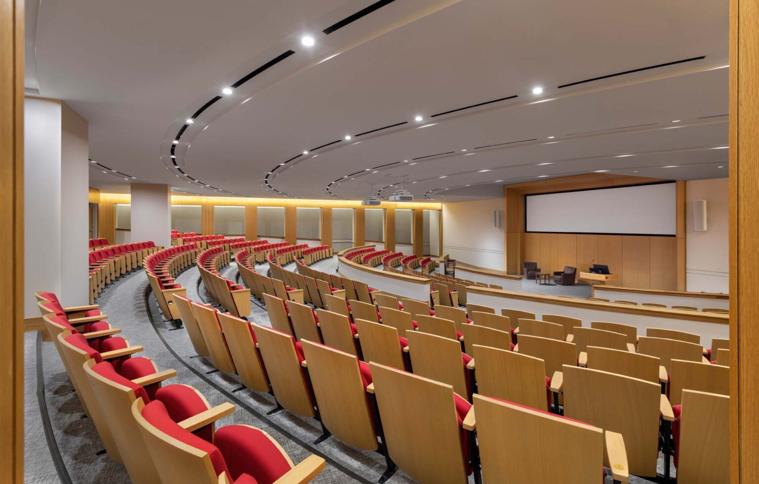 Tiered lecture hall at the SMU Cox School of Business with curved seating layout, integrated technology, and instructor presentation area.