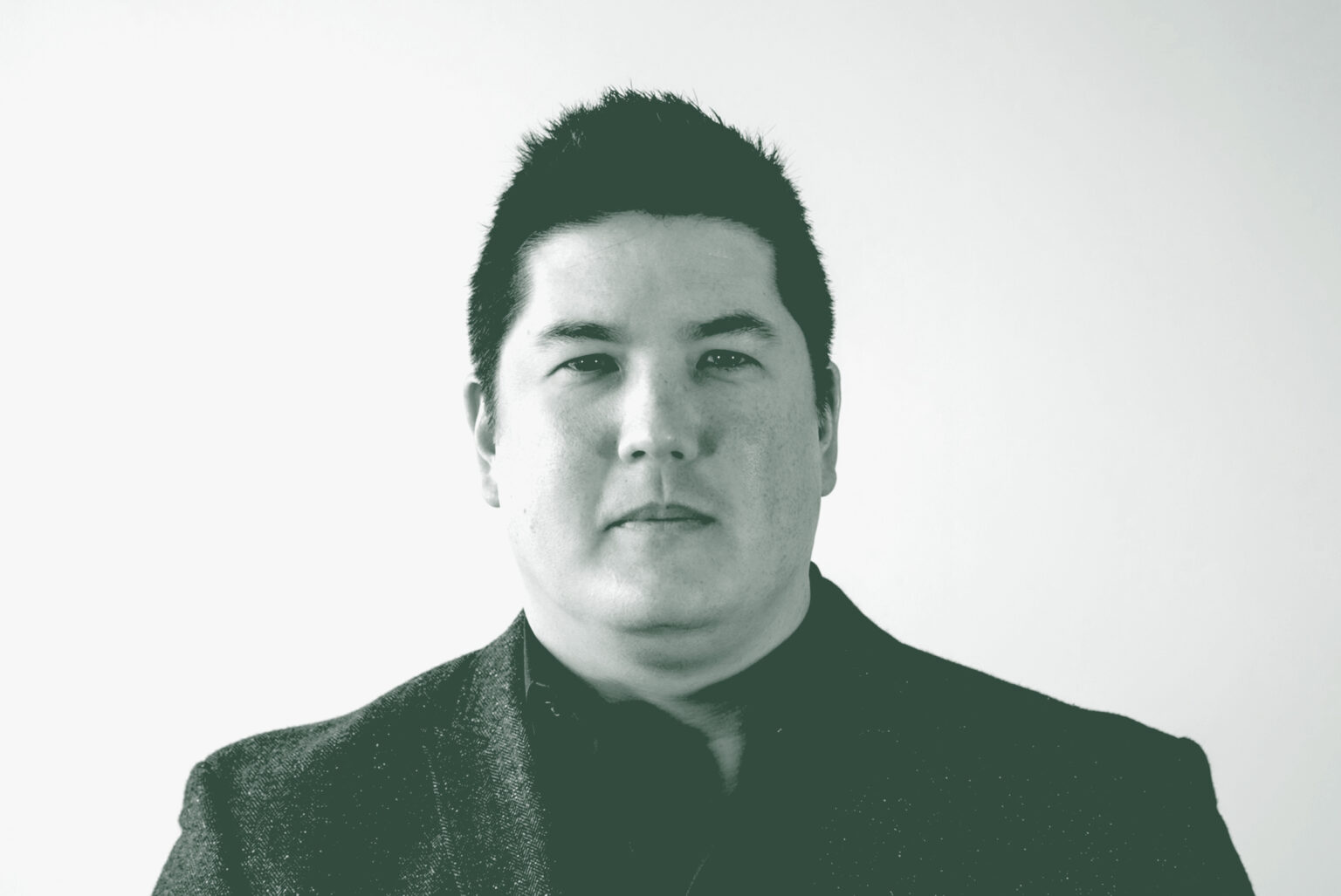A black and white portrait of David Colwill, a Project Leader with GFF in the Civic & Cultural Studio, in front of a white background.