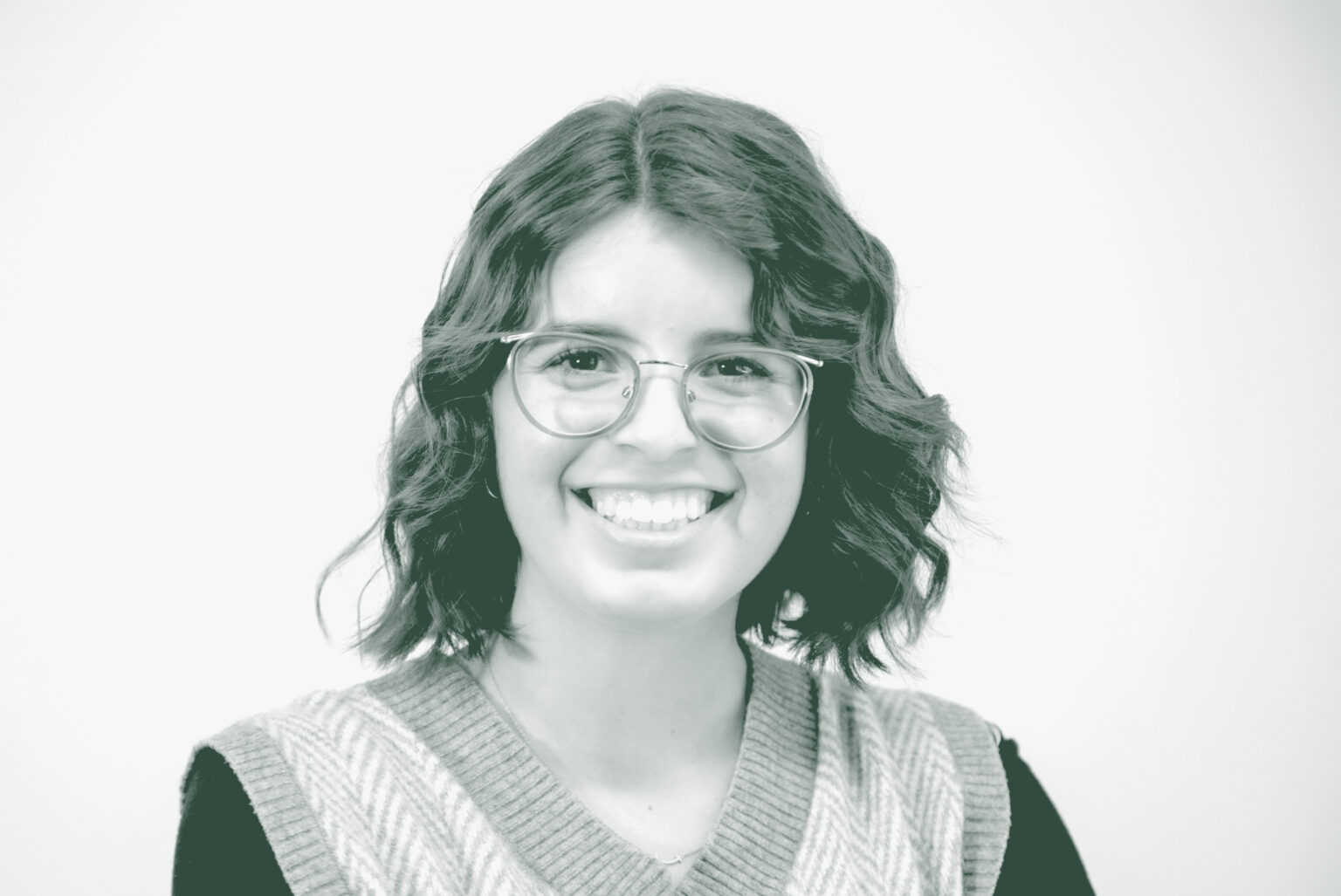 A black and white portrait of Gabrielle Duran, a Project Coordinator with GFF in the Austin Studio, in front of a white background.