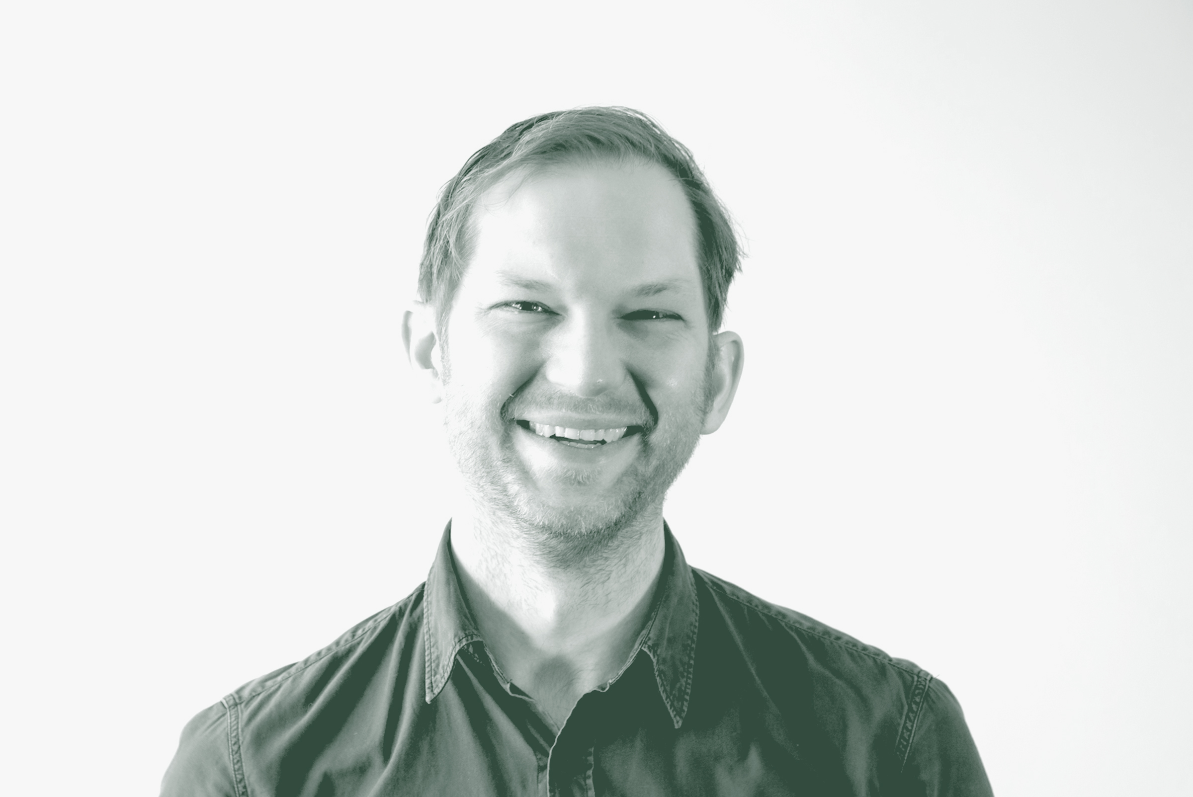 A black and white portrait of Gavin Newman, an Associate and Planning Leader with GFF in the Planning Studio, in front of a white background.