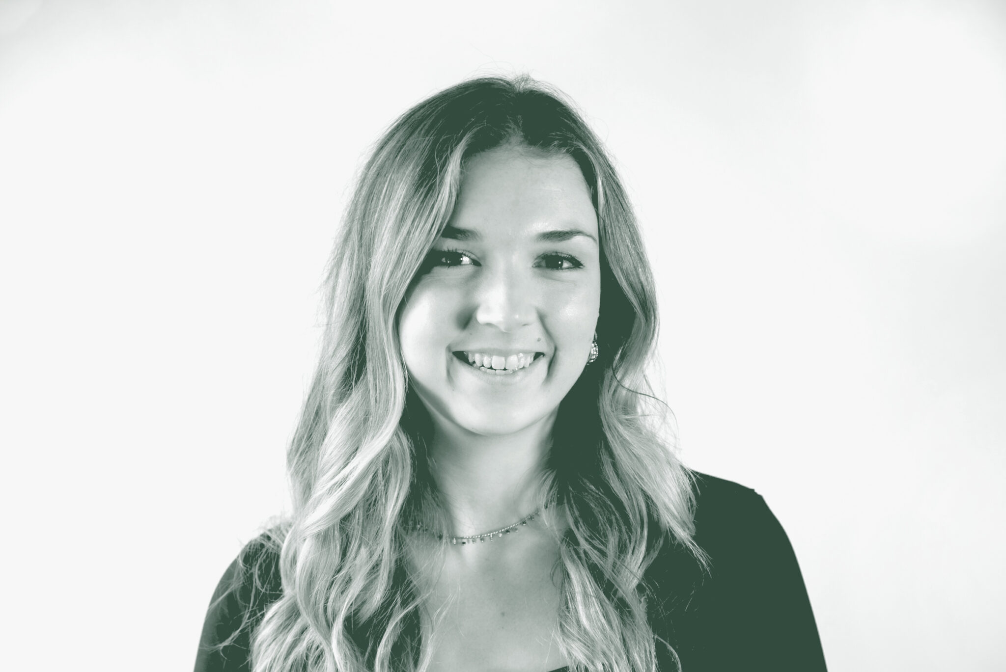 A black and white portrait of Hollyann Friloux, an Interior Design Coordinator with GFF in the Interior Design Studio, in front of a white background.