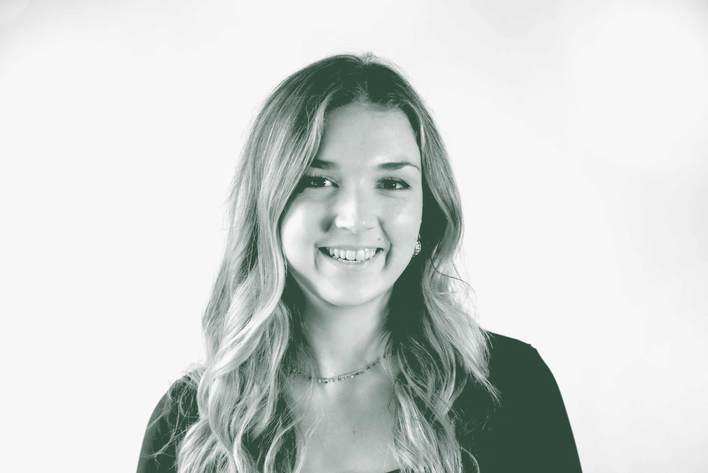 A black and white portrait of Hollyann Friloux, an Interior Design Coordinator with GFF in the Interior Design Studio, in front of a white background.