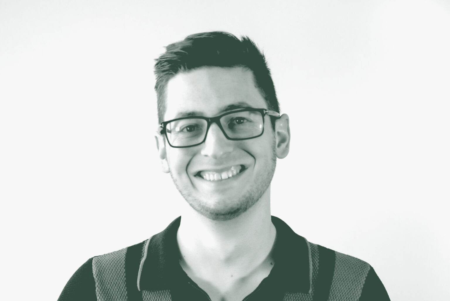 A black and white portrait of Josh Hafel, a Design Technology Leader with GFF, in front of a white background.
