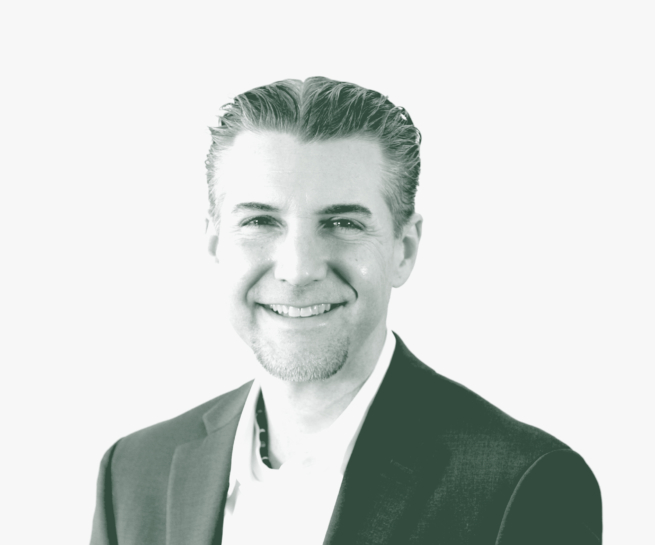 A black and white portrait of Rocky Owens, a Project Leader with GFF in the Office & Workplace Studio, in front of a white background.