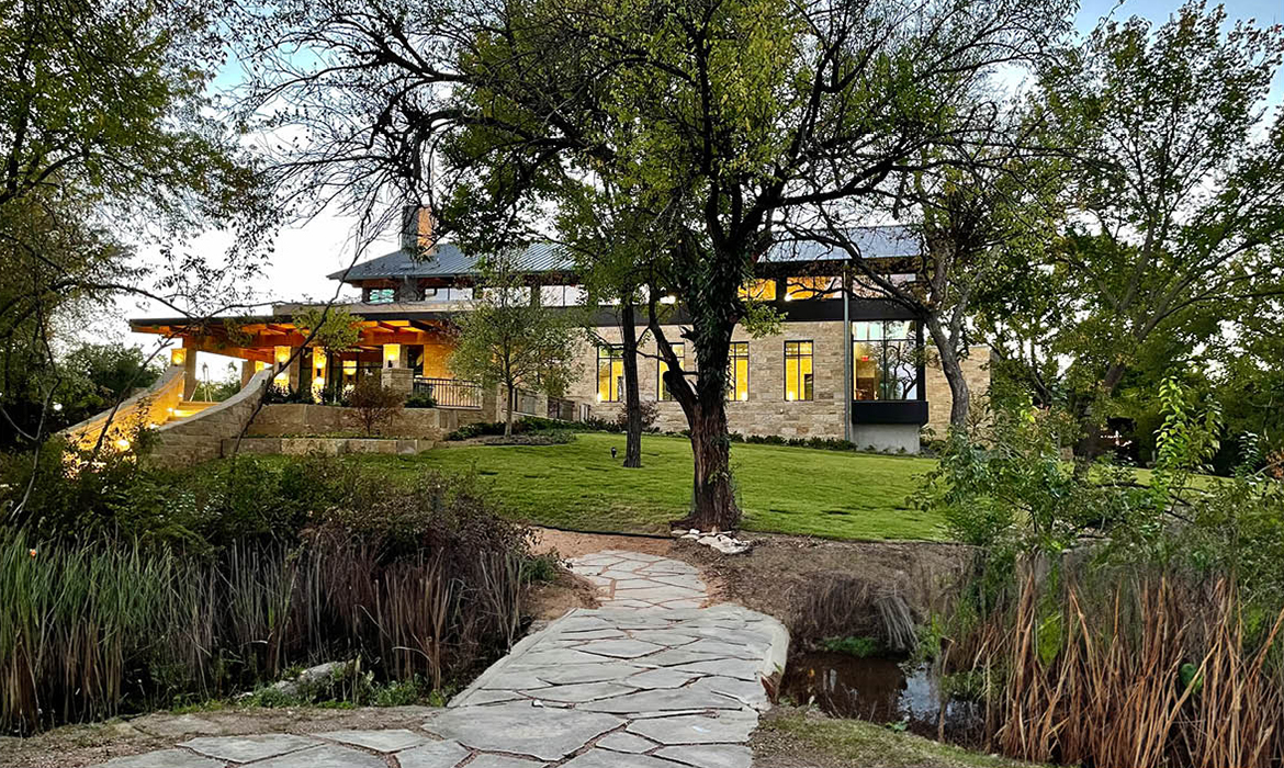 Hasley Chapel's exterior entrance, viewed from a stone path through lush greenery and natural landscaping.